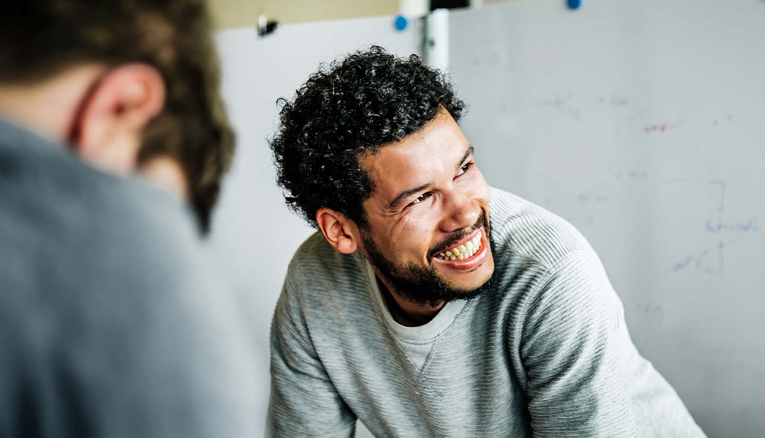 young man smiling and collaborating