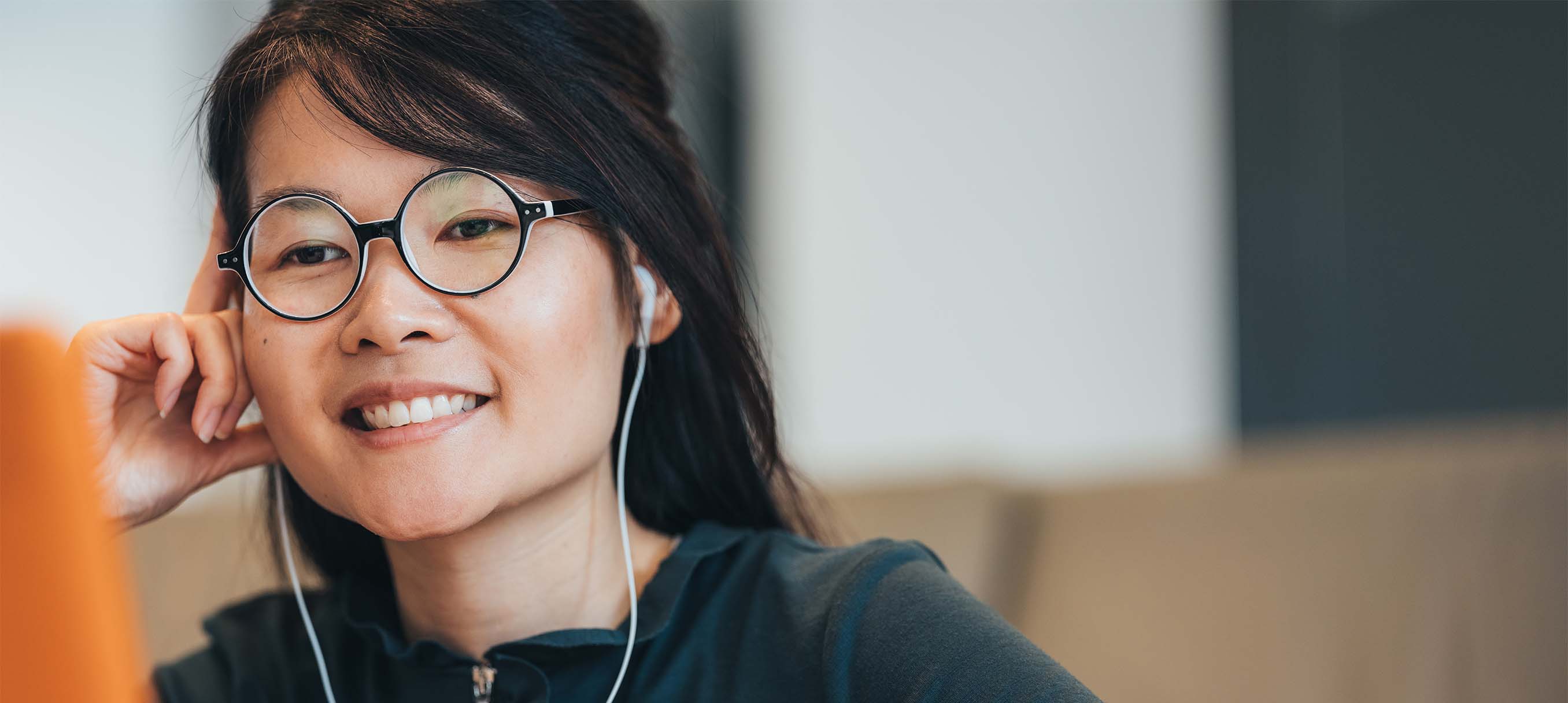 woman in glasses and headphones listening to device